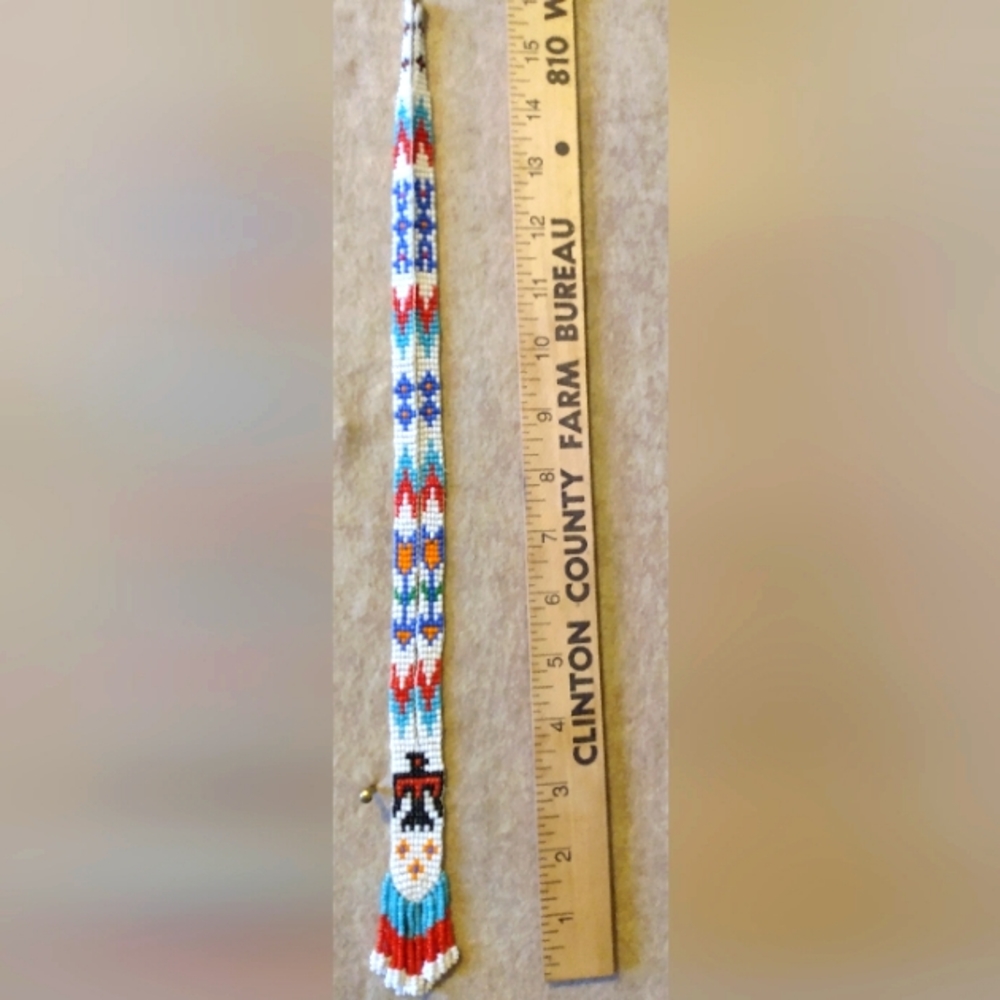 Native American beaded necklace with eagle and arrows .